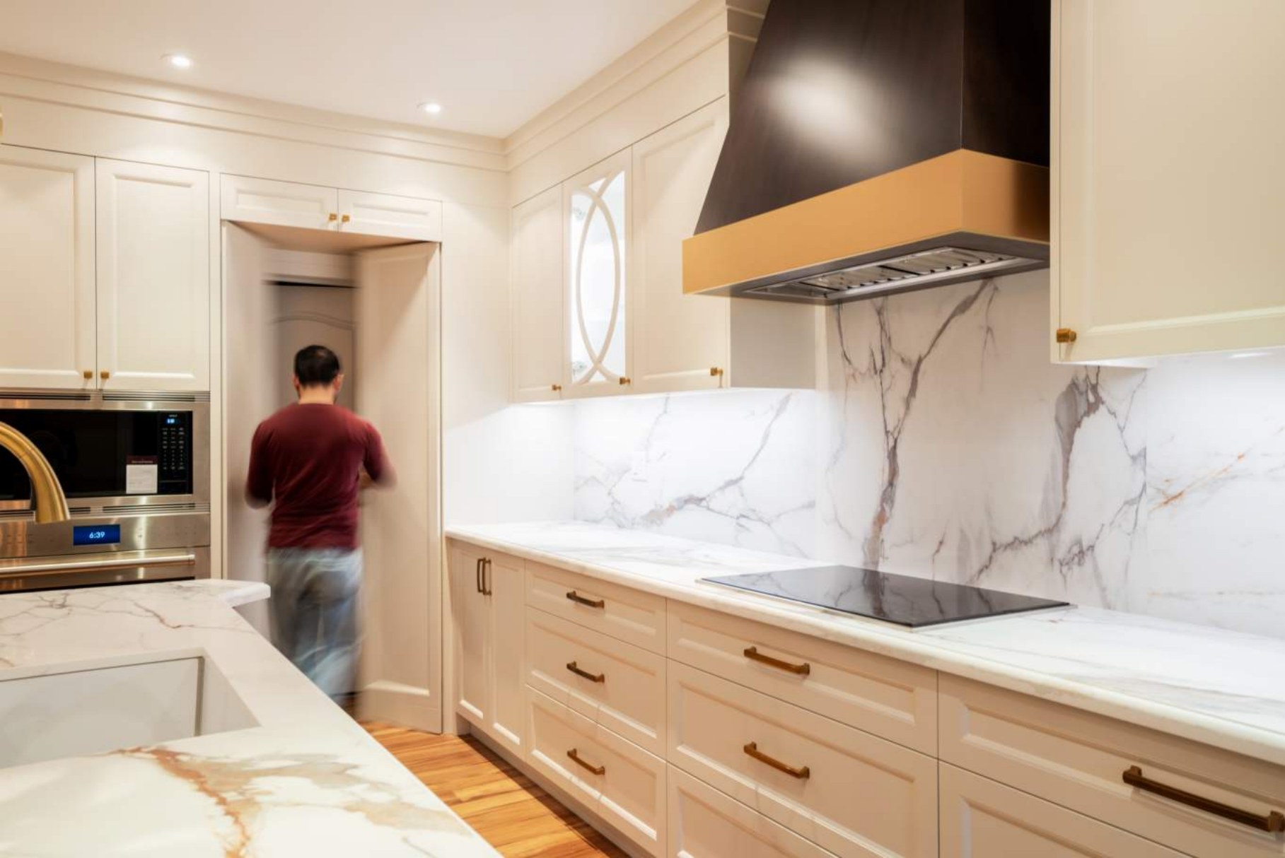 Cooktop run with marble backsplash and concealed pantry entry
