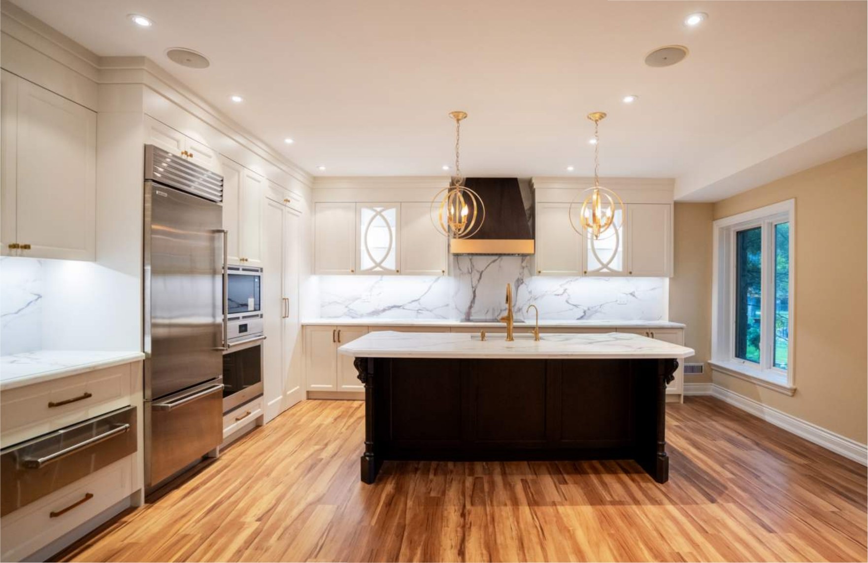 Kitchen island and range wall with marble slab backsplash and custom hood