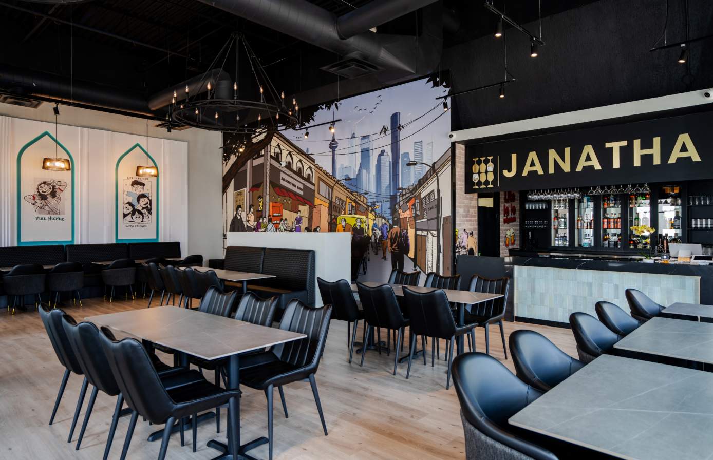 Dining tables alongside the full-height mural wall at Janatha Bar
