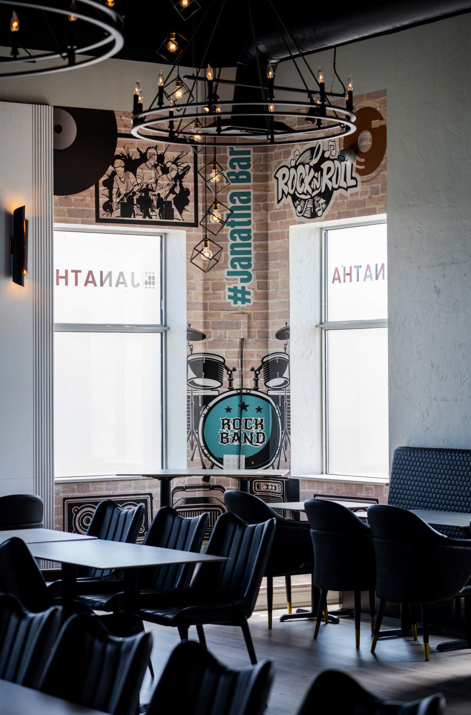 Lounge corner with band-themed artwork at Janatha Bar