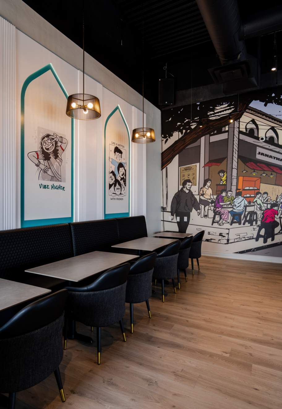 Booth seating with arched illustrated wall niches at Janatha Bar