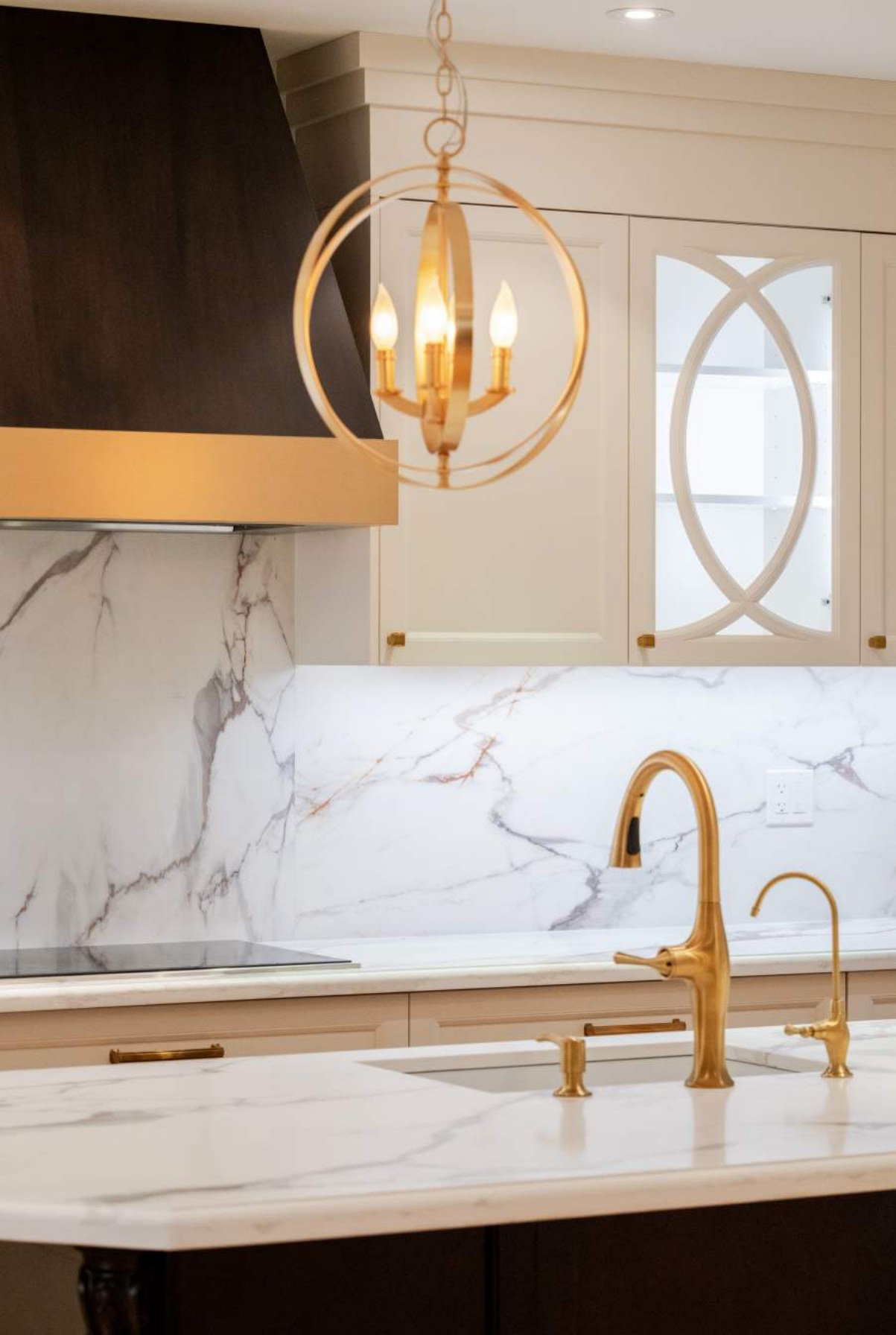 Marble island with brass faucet and orb pendant lighting